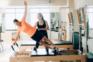 two women on the Pilates Reformer - 5 facts why pilates rocks your body every time