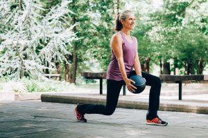 woman doing a lunge - The Science Behind Sweating AFTER You Exercise in Menopause