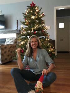woman sitting in front of Christmas tree -5 Tips To Escape The Holiday Stress