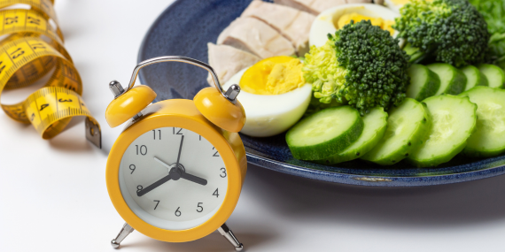  A clock with a plat of food, eggs, broccoli, cucumber.