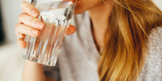 woman drinkig water - how to measure fitness progress by tracking hydration