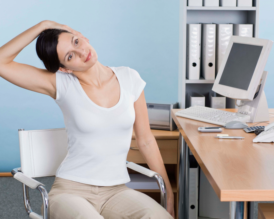 woman stretching neck at office desk