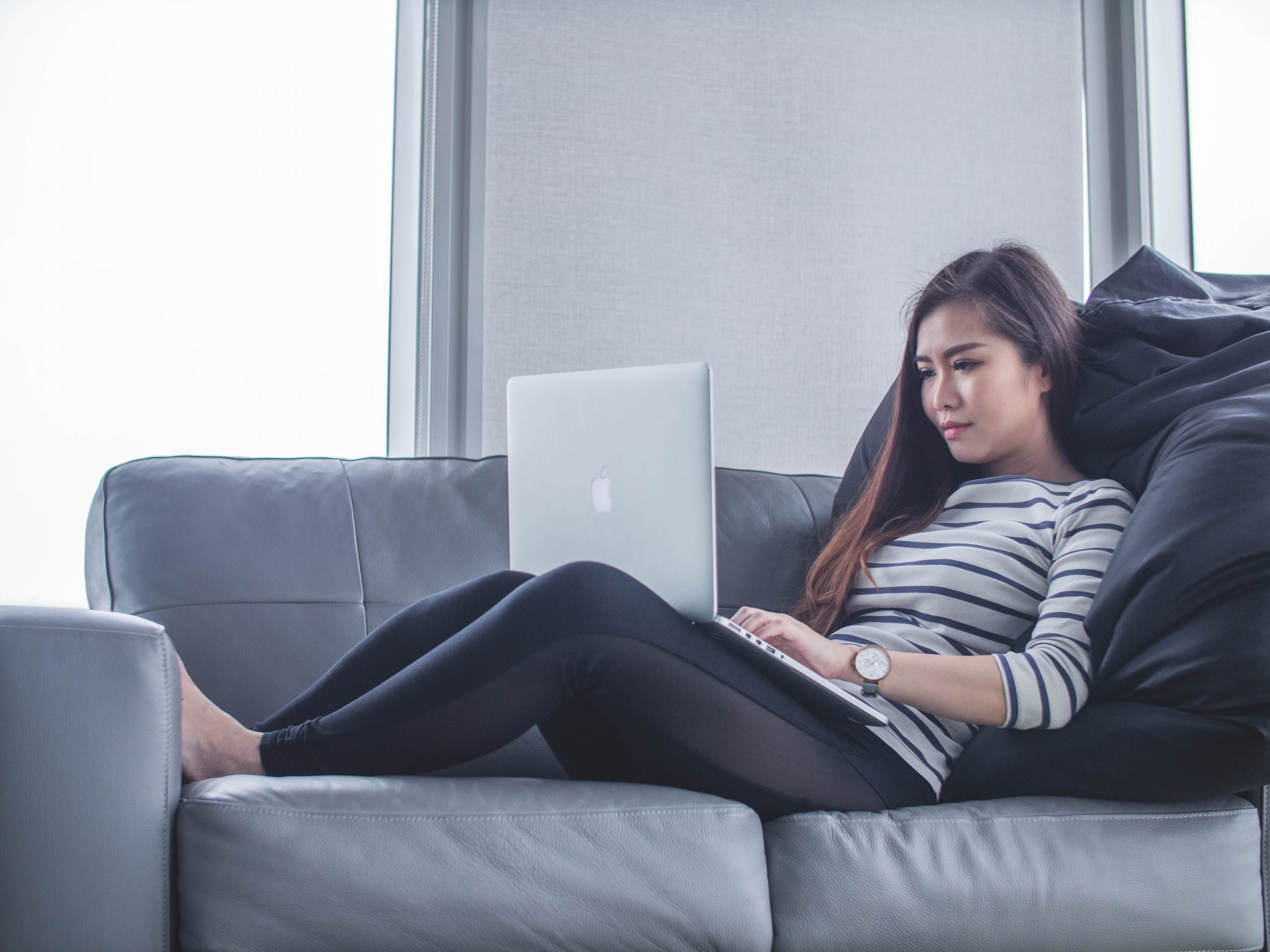 woman on couch with laptop - 5 mistakes to avoid working from home