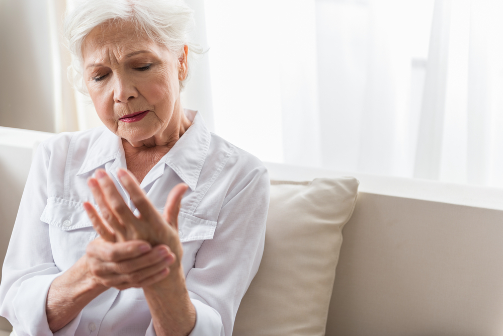 elderly woman holding hand in pain - prevent and relieve joint pain - heike yates
