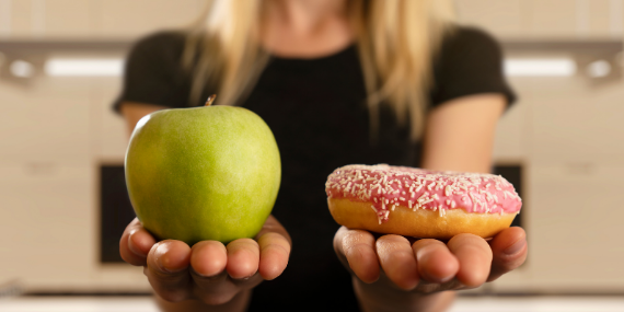 Woman choosing between cravings or healthy food - HELP! HOW CAN I STOP MY FOOD CRAVINGS? - heike yates