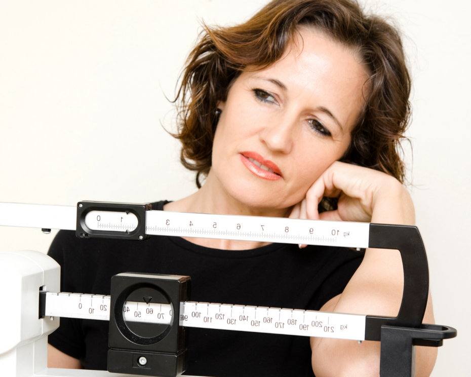 Woman frowning at scale - What you can do if you’re struggling to lose weight - hHike Yates