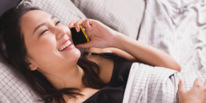 woman talking on phone in bed -5 Practical Ways To Stop Sabotaging Yourself - Heike Yates