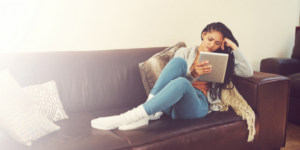 woman watching tv on couch - Heike Yates