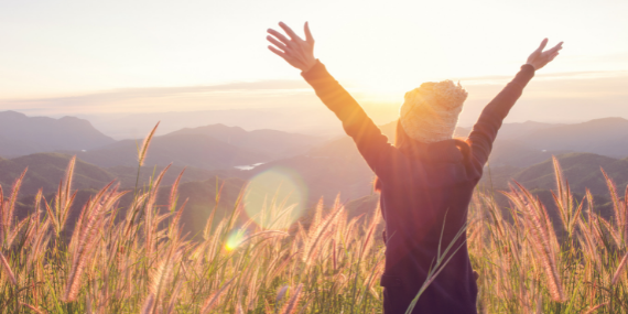woman celebrating the sun rise - 3 tips to stop comparing yourself to other women - Heike yates