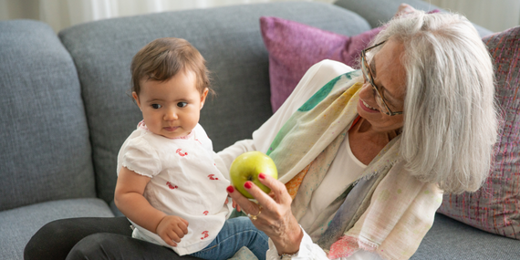3 Compelling Reasons To Start Pilates Over 50 And Make It A Habit - gandma playing with grand kid and apple