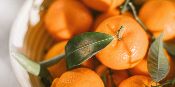 mandarin oranges with stems and leaves in a bowl 5 Ways To Improve Heart Health For Women Over 50 