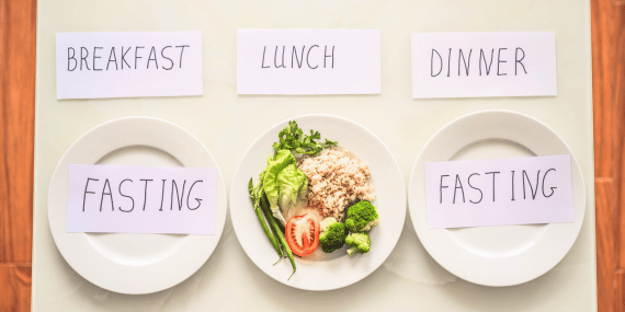 8 Ways To Get The Best Results From Intermittent Fasting Over 50 - plates with signs about fasting