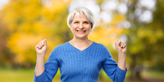 happy woman with fists in the air -10 Age-Defying Fitness and Nutrition Tips for Postmenopausal Women