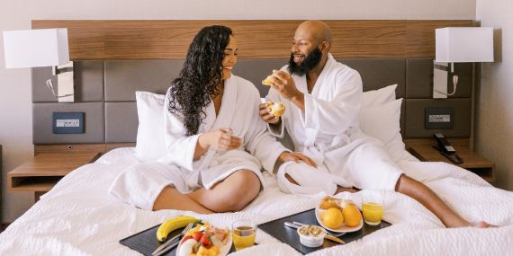 7 Ways To Fight The Holiday Stress - couple eating breakfast in bed