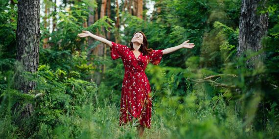 woman standing in a forest breathing - 6 Powerful Ways to Boost Your Midlife Wellness