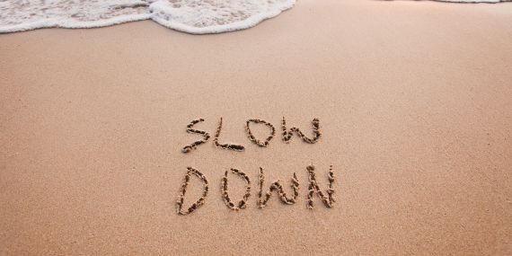 slow down written in the sand