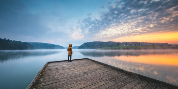 woman standing at a dock on a lake -  The #1 Step to Reclaim Your Fall Routine Now