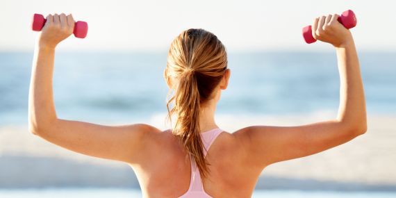 woman from the back holding a pair of dumbbels