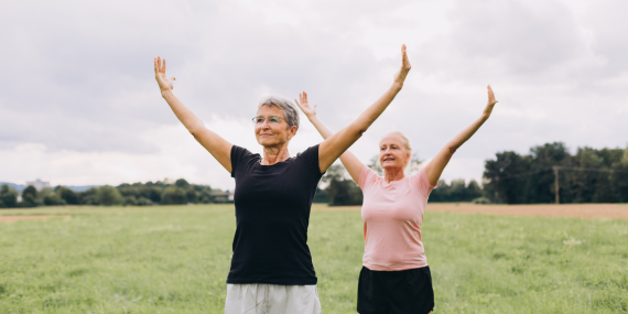 two women stretching their arms up, yoga, fitness, midlife, fitness, How to Build Confidence and Find Your Purpose