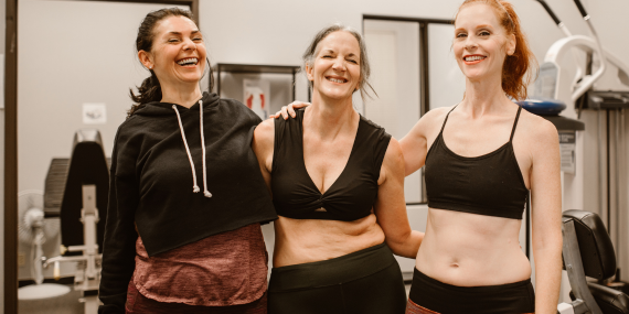 three women smiling in the gym. midlife confidence, fitness, wellness, health over 50