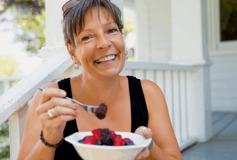 Midlife Nutrition How to Stop the 2 P.M. Crash : woman enjoing a bowl of fruit