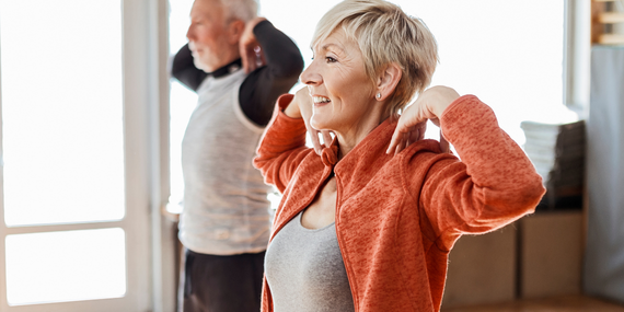 a couple touching their shoulders in midlfie exercise class