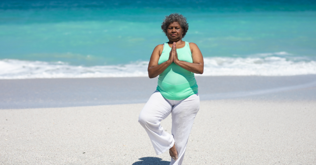 Feeling Stuck in Midlife? Here’s the Real Reason. woman doing yoga on the beach