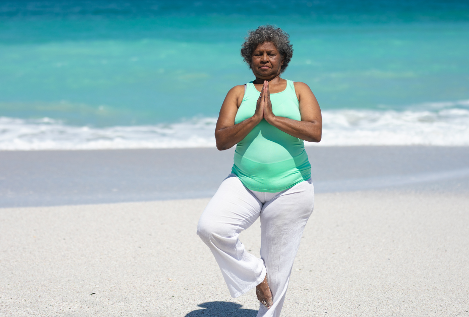 Feeling Stuck in Midlife? Here’s the Real Reason. woman doing yoga on the beach