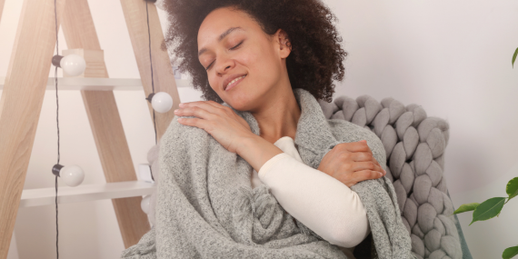 woman giving herself some self-love and confidence by hugging herself.Building Consistency in Midlife: Why Speaking Up Still Leaves Women Feeling Small