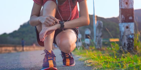 Stop starting over. women kneeling on the ground pressing a button on her watch.