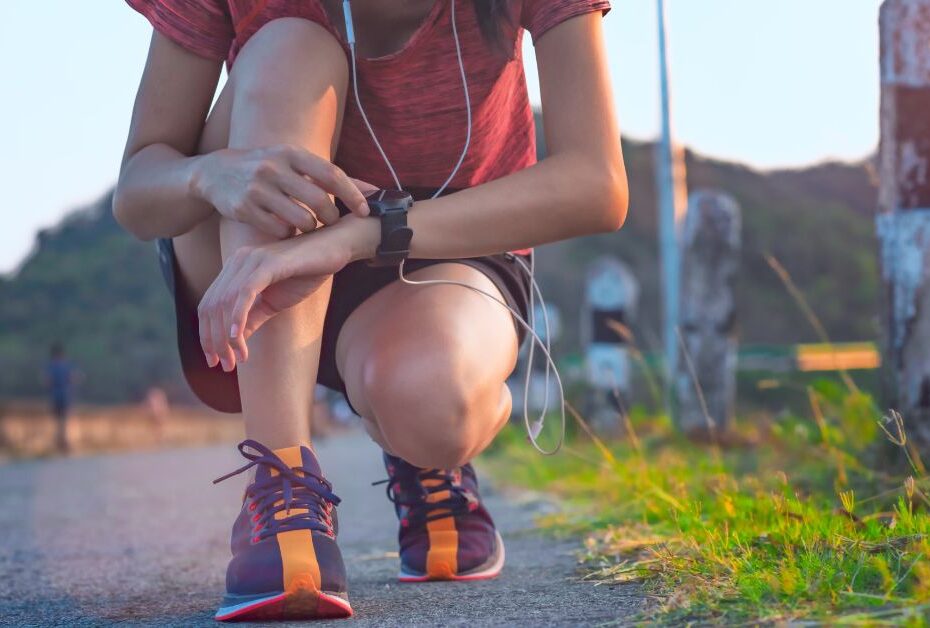 Why Women in Midlife Keep Resetting Their Goals. STop starting over in midlife. women kneeling and pressing a running watch to start.