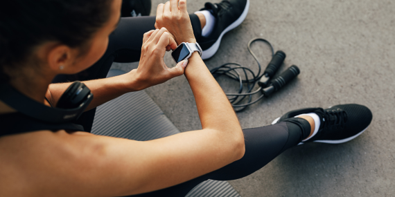 When Familiar Midlife Fitness Habits Stop Working. Woman sitting in the gym setting her watch.