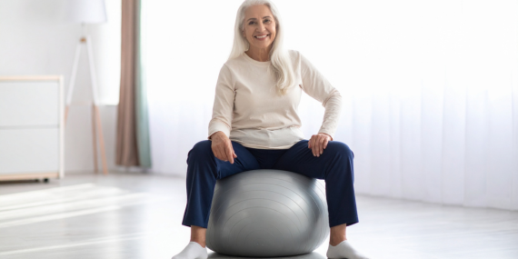 When Familiar Midlife Fitness Habits Stop Working. Midlife woman sitting on a stability ball. 